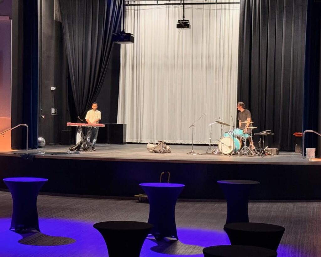 Musicians preparing on an empty stage.